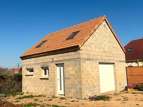 Garage en parpaing coiffé de sa toiture en tuiles